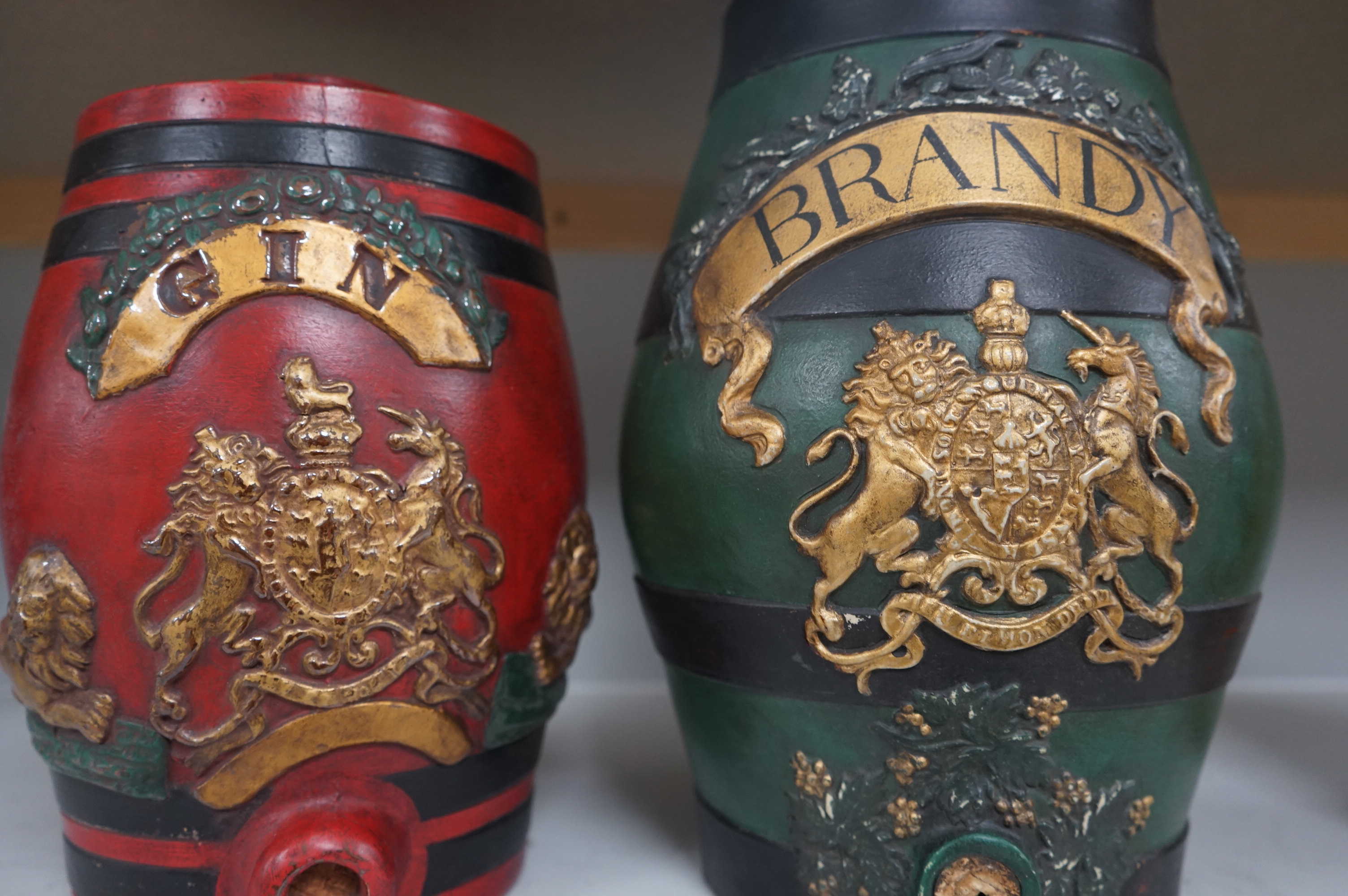 Two stoneware spirit barrels, later cold painted and mounted as lamp bases, 'Brandy' and 'Gin', tallest 34cm. Condition - fair to good